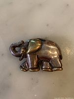 Front view of elephant-shaped sterling silver brooch with visible tarnish.