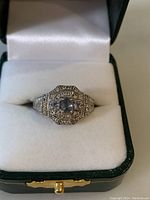 Front view of sterling silver Art Deco ring showing central oval stone and surrounding smaller stones with detailed filigree.