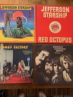 Four vinyl LP record covers with Jefferson Starship, Jefferson Airplane's Red Octopus, and Creedence Clearwater Revival albums Cosmos Factory and Pendulum.