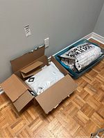 Photo showing unopened package with queen-size comforter inside a plastic bag with black and white text design.