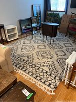 Rug visible on a wooden floor with furniture around it showing the full size and pattern of the rug.