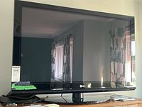 Full front view of the TV showing screen and swivel stand.