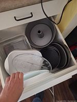 Drawer with metal tube pan, glass bakeware and perforated pizza pan