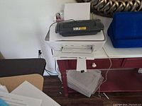 Wide view of Canon printer with paper shredder on top on a small table, showing condition and setup.