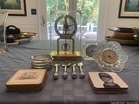 Overview of assortment on table including clocks, coasters, knives, and decorative drink coasters.