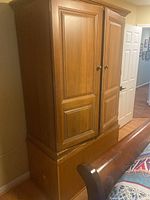 Maple entertainment center with base and cabinet units, closed doors visible on cabinet.