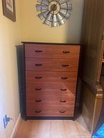 Front view of IKEA chest of drawers showing six drawers with wood finish and black handles.
