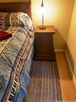 Nightstand placed next to bed showing size and top surface