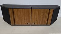 Photo showing the pair of Bose 4.2 speakers side by side, wood panel fronts and black fabric ends visible.