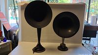 Two antique horn speakers, one Westinghouse and one Sparta/Fuller, shown side by side against a white backdrop