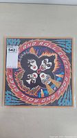 Front cover of KISS 'Rock And Roll Over' vinyl LP album showing cartoon-style band member illustrations and title text.