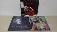 Photo showing the 3 vinyl LP albums including Stevie Nicks, Madonna, and Grace Slick album covers laid flat on table.