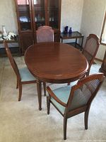 Overall view of oval dining table with four chairs in room setting