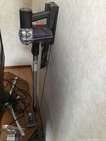 Full view of Dyson V6 Origin mounted on wall dock with main tube and floor head attached