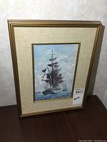 Overall view of the framed Keirstead print showing the ship under cloudy sky.