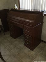 Front view of the modern roll top desk showing the roll top closed and five drawers with brass handles.