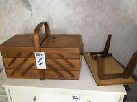 Wooden sewing stand base upside down showing detached legs.