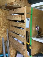 Wooden drawers filled with various tools and hardware including chisels and pliers hung on side.