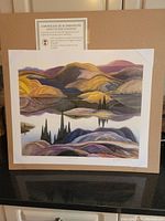 Unframed offset plate lithograph titled Mirror Lake by Franklin Carmichael, displayed on a flat surface with certificate of authenticity above.