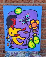 Full frontal view of the acrylic painting on canvas depicting a stylized boy with nature elements in vibrant colors hung against a brick wall.