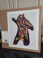 Full view of colorful offset plate lithograph titled Bear Spirit by Don Chase, showing white border and taped on a board.