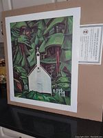 Photo of the unframed offset plate lithograph "Indian Church" by Emily Carr showing the print on a cardboard backing with certificate of authenticity visible.