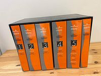 Five boxed Benjamin Moore Professional Reference Sets labeled 1 through 5 in a black slipcase on a wooden table.