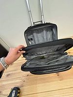 Top-down view showing open interior compartments of the suitcase, highlighting lining and organization.