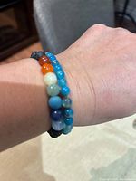 Bracelets worn on wrist with multi-colored chakra beads visible