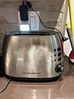 Front view of Hamilton Beach stainless steel 2-slice toaster showing control buttons and rotary dial.