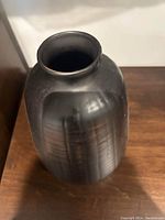 Top-down view of the black vase showing shape and matte finish.