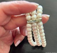 Close-up of the stretchable pearl bracelet showing detail of the white pearl beads and one silver-tone spacer with zirconia stones.