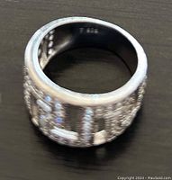 Close-up of the ring's exterior showing the silver band with embedded Swarovski stones forming a Greek Key pattern.