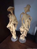 Front view of male and female Oriental figurines on decorative bases