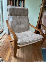 Full view of the arm chair showing the upholstered seat and back, wooden curved armrests, and sled-base frame.