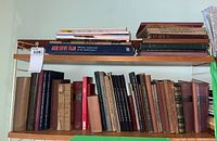 Shelf of vintage German books, showing a mix of hard and soft covers with worn spines