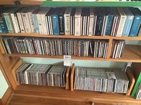 Wide view of wooden shelves containing a large number of classical music CDs, including boxed sets and single jewel cases arranged neatly.