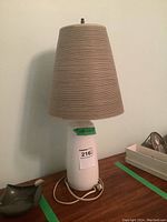 Full view of lamp with shade attached over table.