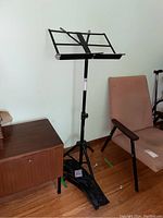 Full view of Yorkville BS321 black adjustable music stand with tripod base and foldable sheet holder.
