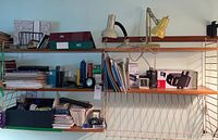 Shelving view showing assorted notebooks, binders, lamps and picture frames