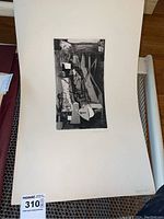 Overall photo showing the abstract sketch centered on a large cream mat board, with signature visible in lower right corner of sketch area.