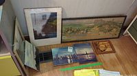Five photo prints displayed on wood floor and against wood panel wall showing the variety of images in the lot including cityscape, hunt scene, Statue of Liberty, and landscape.