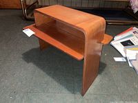 Side profile view showing the curved top and integrated lower shelf