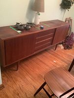 Three-quarter front view of full credenza on legs with drawers and sliding doors