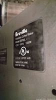 Close-up of the Breville espresso coffee maker model label with specifications and certification marks.