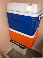 Stacked coolers: blue Rubbermaid cooler on top, orange Rubbermaid cooler in the middle, white Coleman cooler on the bottom.