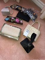 Overall display of seven evening bags highlighting various styles, colors and textures including beaded, embroidered, and woven materials.
