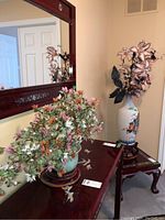 Photo of two faux bonsai floral arrangements displayed on wooden furniture with mirror