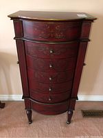 Full front view showing six curved drawers with gold scroll decoration