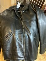 Front view of one black leather men's jacket with collar and zipper closure.